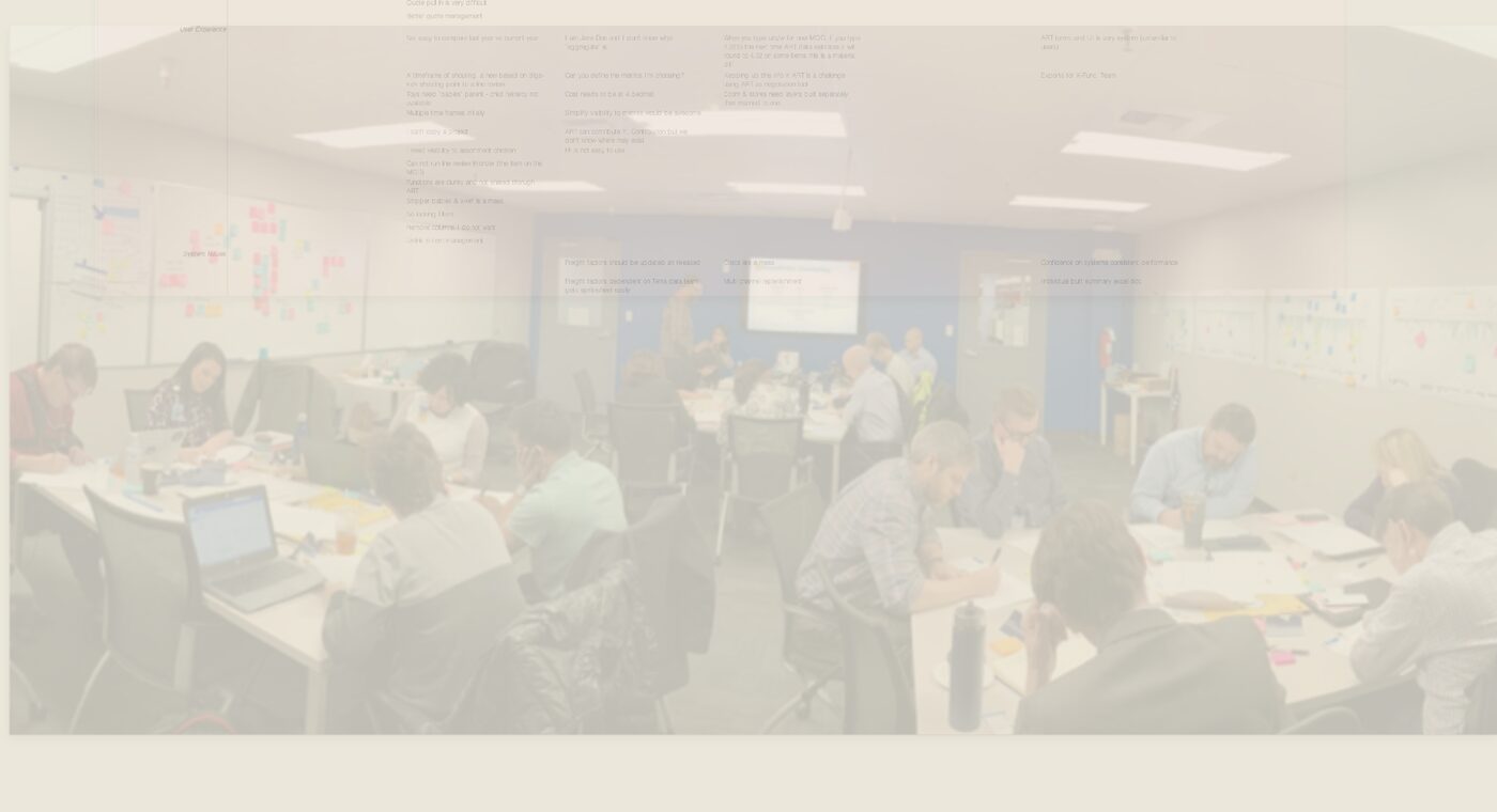Anonymized photograph of a design-sprint workshop room with a cross-functional team working at tables covered in notes and printed materials, with a facilitator presenting at a whiteboard.